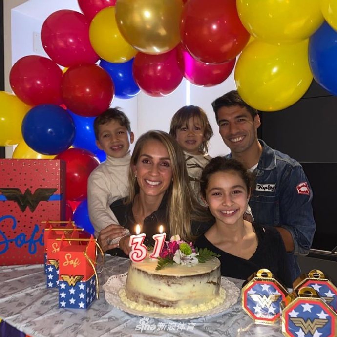 苏亚雷斯与妻子索菲亚在温馨灯光下相依，他温柔地亲吻着妻子的脸颊，索菲亚则绽放出幸福而甜蜜的笑容，仿佛整个世界都只剩下彼此