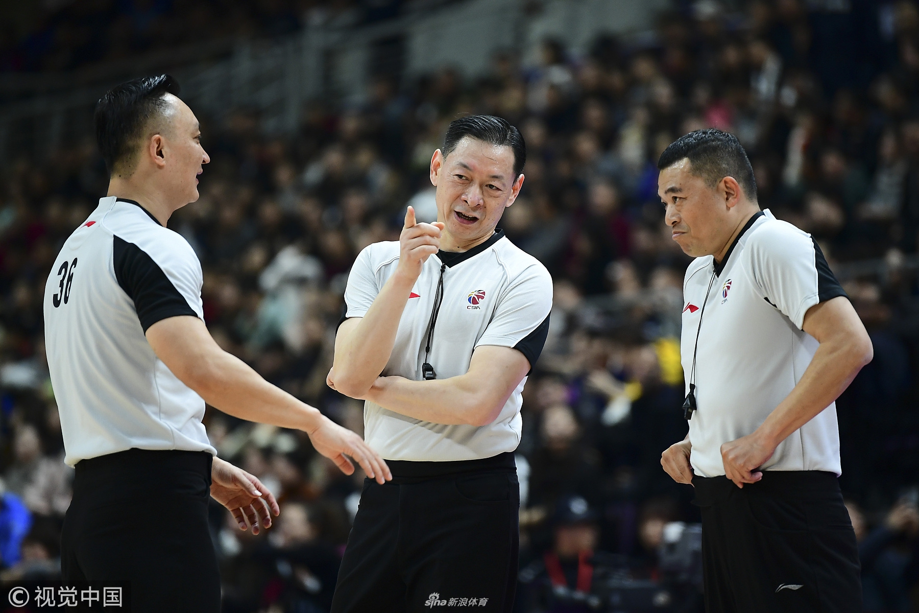 执法裁判神情严肃地站在技术台前，将听筒紧贴耳边，正在与CBA视频回放中心进行紧急连线，他面前的技术台屏幕上，正定格着那个引发争议的瞬间画面。