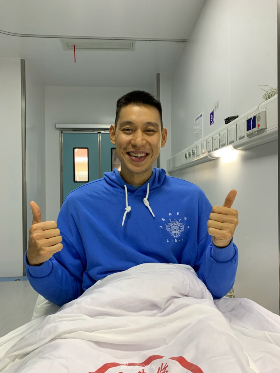 在医院的病房内，林书豪正在与队友进行视频连线，他面带笑容地对着手机屏幕挥手，似乎在告诉伙伴们自己情况良好，不用担心。