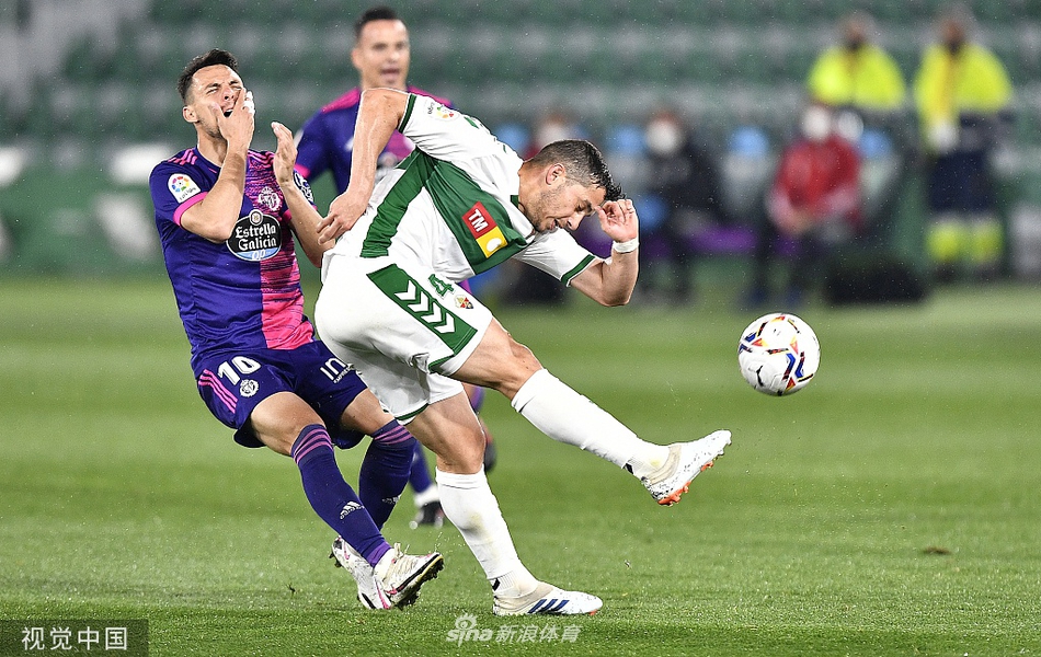 巴拉多利德前锋在埃尔切禁区内高高跃起争抢头球，身边是两名贴身盯防的防守球员，皮球在空中划过一道弧线，门线上的危机一触即发。