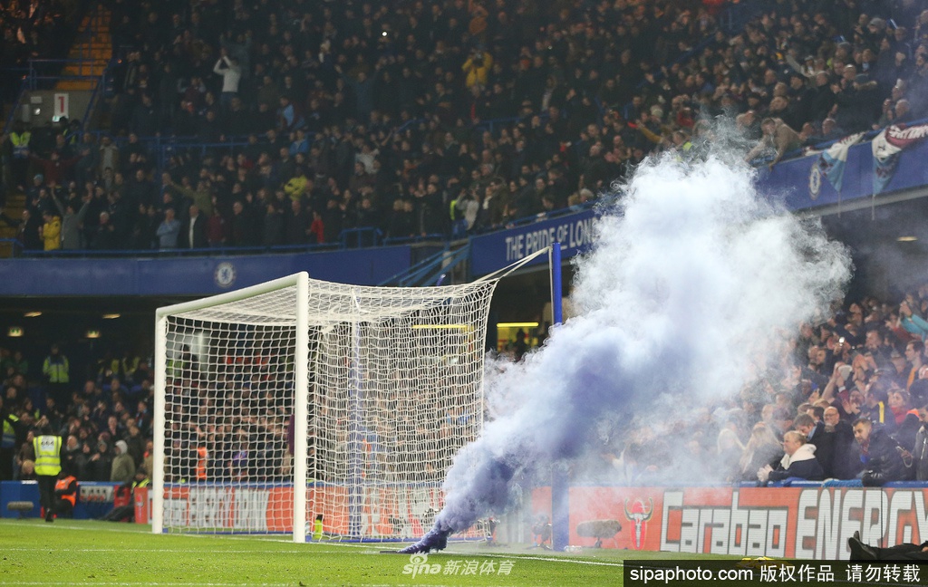 空旷的斯坦福桥球场看台上，一排排空无一人的蓝色座椅整齐排列，阳光透过顶棚洒下斑驳光影，往昔山呼海啸的喧嚣此刻化作寂静，仿佛在静默等待着球迷早日归来。