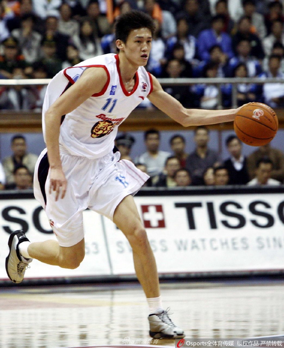 身穿宏远青年队队服的周鹏,脸庞还带着婴儿肥,对着镜头露出羞涩而纯真的微笑,身后是简陋的训练馆墙壁