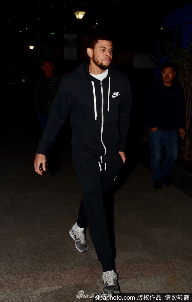 麦卡勒姆在场边拉伸时与队友轻松交谈，脸上带着笑意，似乎已经融入了球队的氛围，场边的球迷迫不及待地举起手机记录这一刻