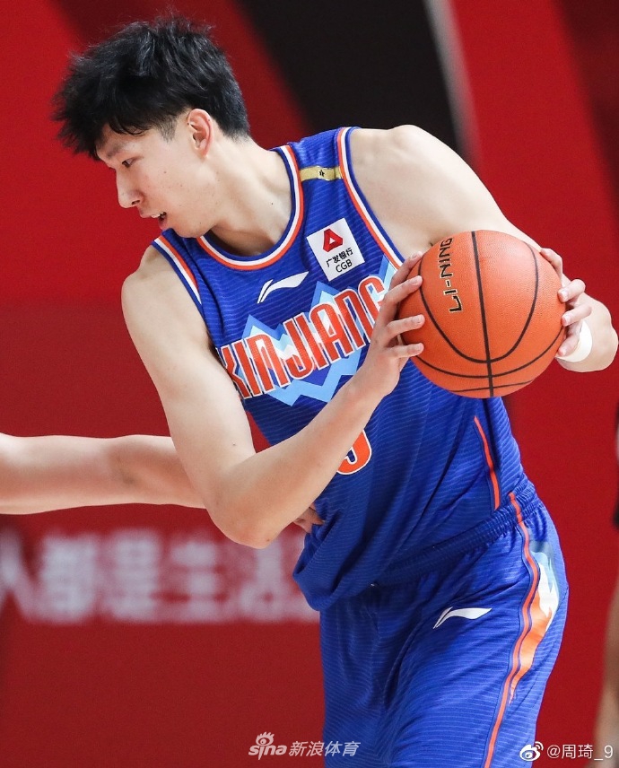 周琦受伤瞬间表情痛苦，手捂左脚跟腱，眼神中透露出不甘与焦虑，队友们围在一旁神情紧张