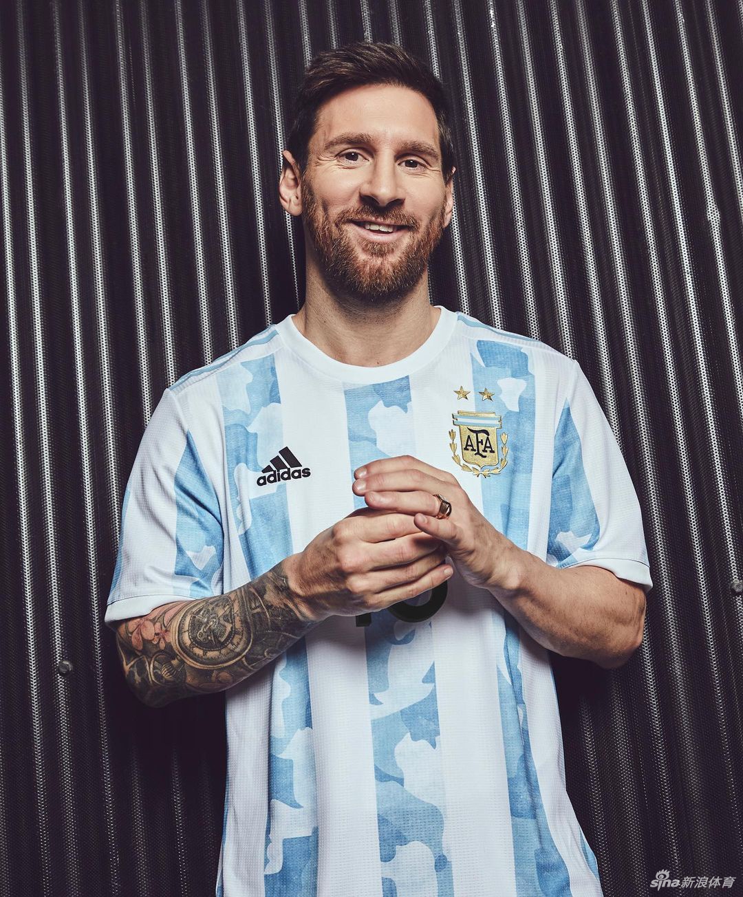 梅西眼神坚毅地凝视远方，他身着全新的蓝白条纹战袍，球衣上独特的迷彩暗纹在光影下若隐若现，仿佛将阿根廷广袤山河的脉络披在了肩上。
