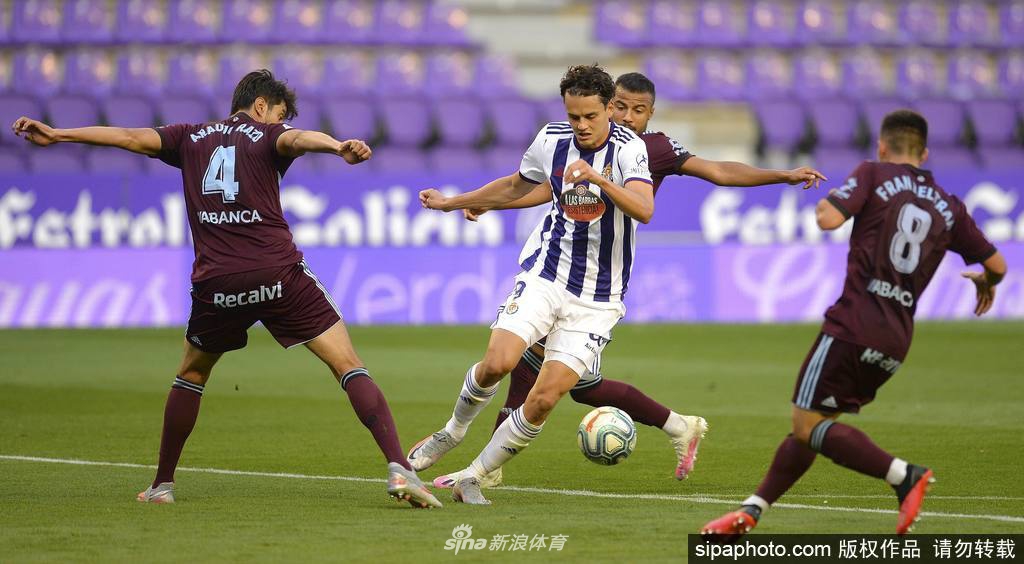 塞尔塔前锋阿斯帕斯神情严肃地站在点球点前，他身后的队友和对手球员都保持着安全距离，整个球门的背景是空无一人的看台，这一瞬间仿佛凝聚了所有压力。