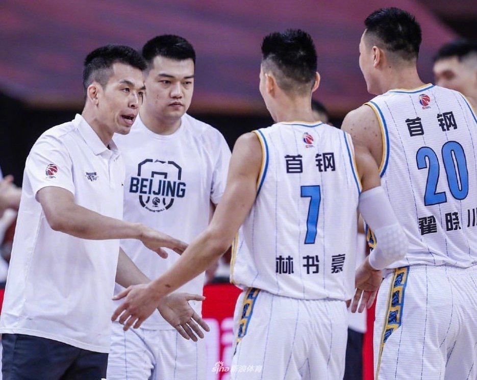 林书豪在队友簇拥下握拳怒吼，脸上挂着汗珠和笑容，身后的比分牌显示着胜利的数字，整个画面充满了团队篮球的热血与激情