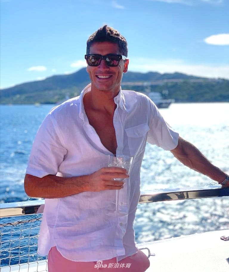 一张极具艺术感的黑白照片，莱万赤裸上身背着包，与穿着黑色连衣裙的妻子手牵手走在林间，阳光透过树叶洒下斑驳光影，充满故事感。