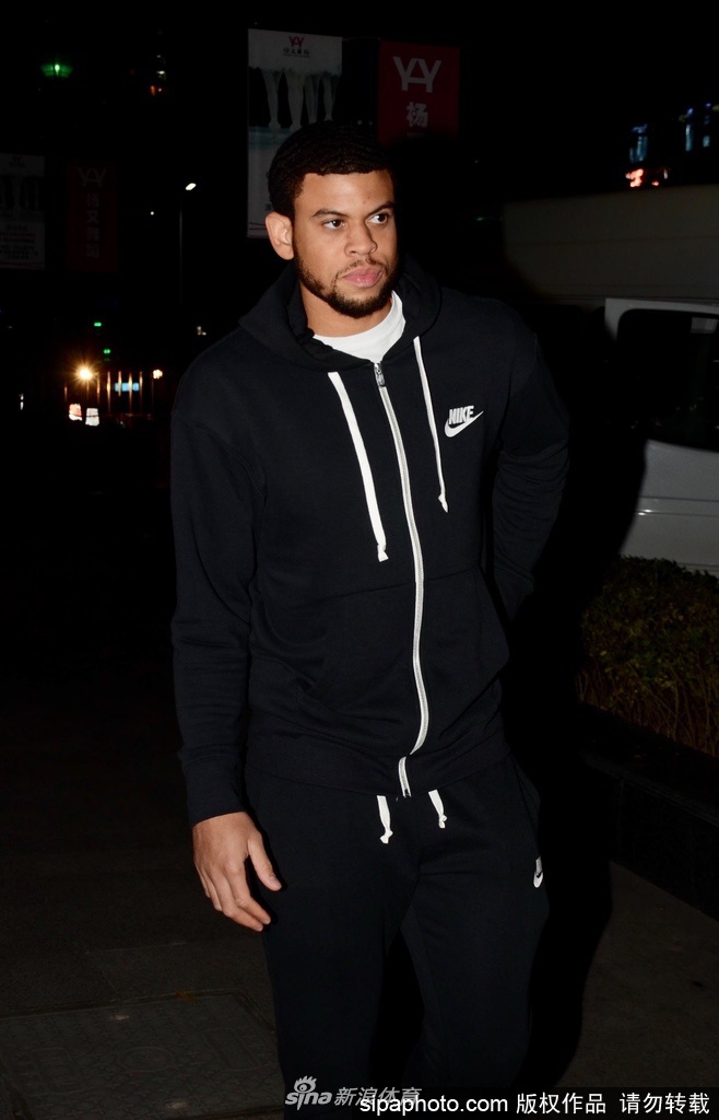 麦卡勒姆面带微笑俯身为热情的球迷签名，周围伸过来的手机和篮球记录着这位试训外援在申城的初次亮相