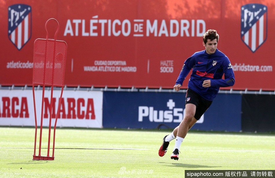 一名马竞球员正在进行标志盘绕杆训练，他身体重心压得很低，触球动作精准而流畅，仿佛在演奏一曲绿茵上的华尔兹。