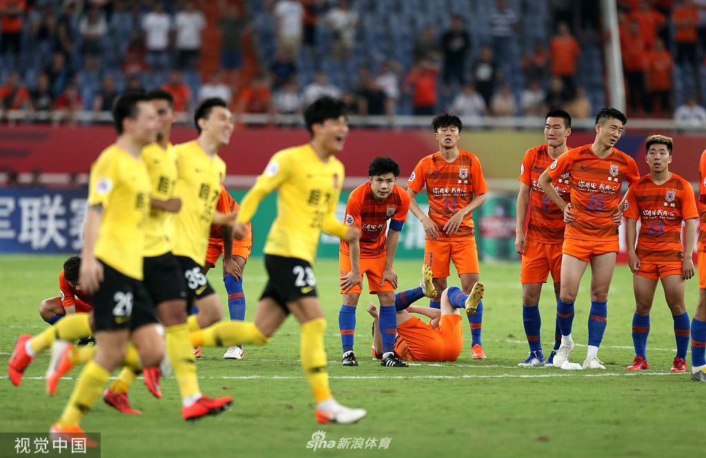 在济南奥体中心漫天橘色纸屑的映衬下，罚失点球的崔鹏垂着头，双手叉腰，巨大的失落感笼罩着他的背影，与远处庆祝的恒大众将形成鲜明对比。