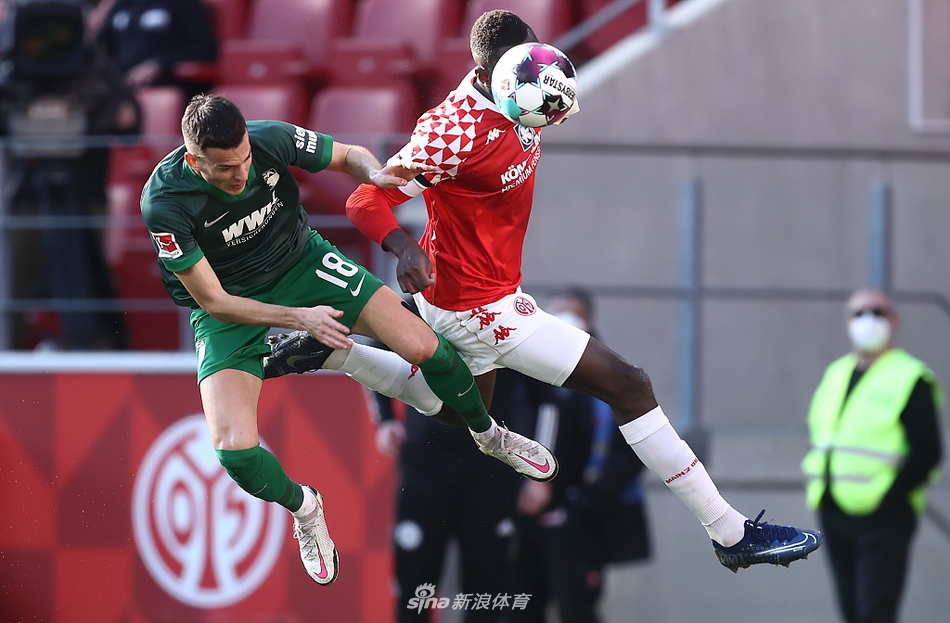 美因茨边路快马姆韦内在草皮上与奥格斯堡悍将弗伦贝格进行百米冲刺般的激烈竞速，两人眼神坚毅如铁，脚下的皮球成为了他们必须征服的唯一目标。