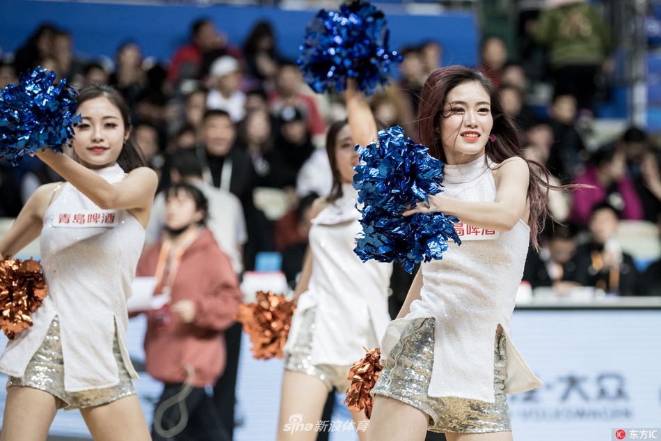 啦啦队成员们在场上围成一圈，伸展手臂展现出优美的身体曲线，仿佛一群优雅的白天鹅在霞光下舞动