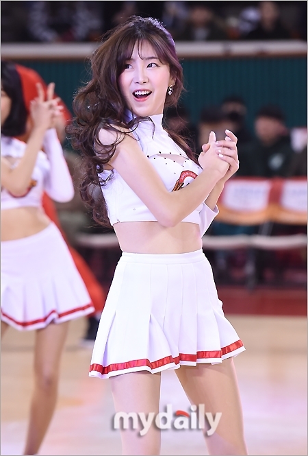 比賽結束的哨聲吹響,啦啦隊員們仍留在場內向觀眾致意。她身著閃亮的舞台裝,臉上掛著真摯的笑容,高舉雙手比出愛心手勢,為這個激情夜晚畫下圓滿句點。