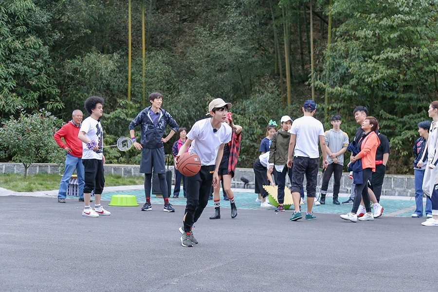 王源在球场上大步流星地运球突破,白色T恤被汗水浸透贴在身上,卡其色帽子下的侧脸轮廓分明,充满了少年特有的力量美感。