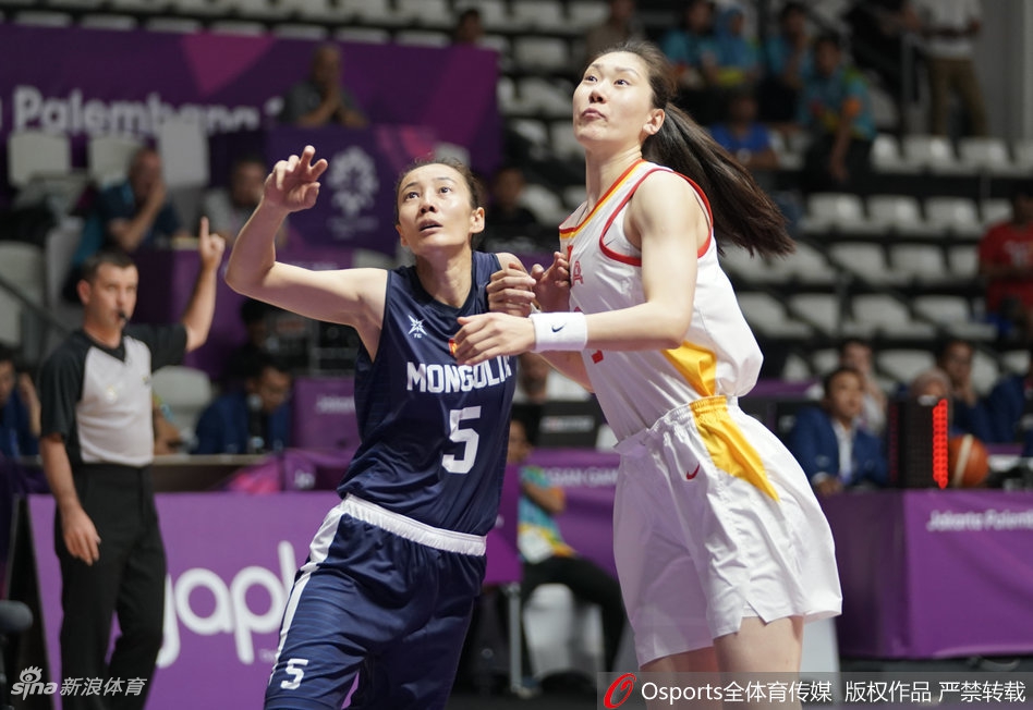 中国女篮核心邵婷持球突破，面对蒙古队两名防守球员的包夹，依然稳健地将球控制在手中，寻找最佳传球或进攻机会。