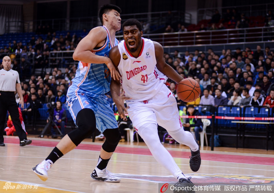 新疆队球员亚当斯在青岛队多人围堵下强行突破，眼神中充满杀气