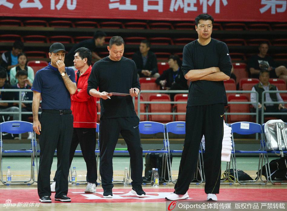 球场边的王治郅神情专注，双手抱胸的他仿佛一座灯塔，用深邃的篮球智慧为场上弟子们指引方向。