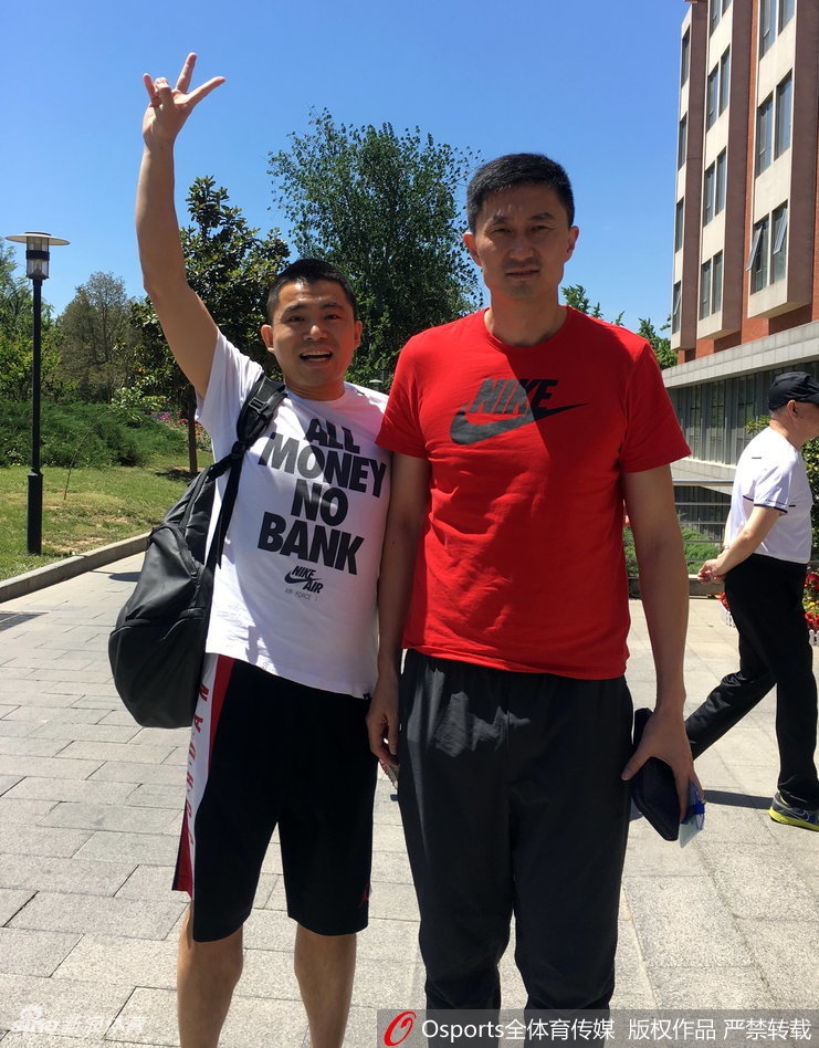 主教练杜锋面带微笑,亲切地与热情的球迷们站在一起合影,现场氛围轻松愉快。