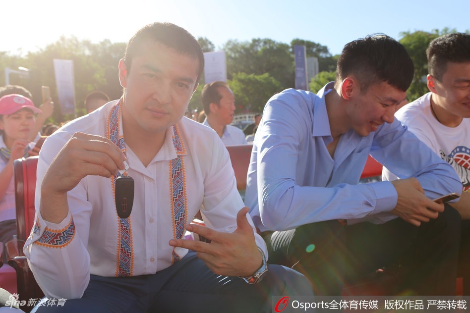 西热力江眼含笑意，高高扬起手中的林肯车钥匙，在镜头前尽情展示着这份沉甸甸的冠军犒赏，身旁的队友们也被这欢乐的气氛感染。