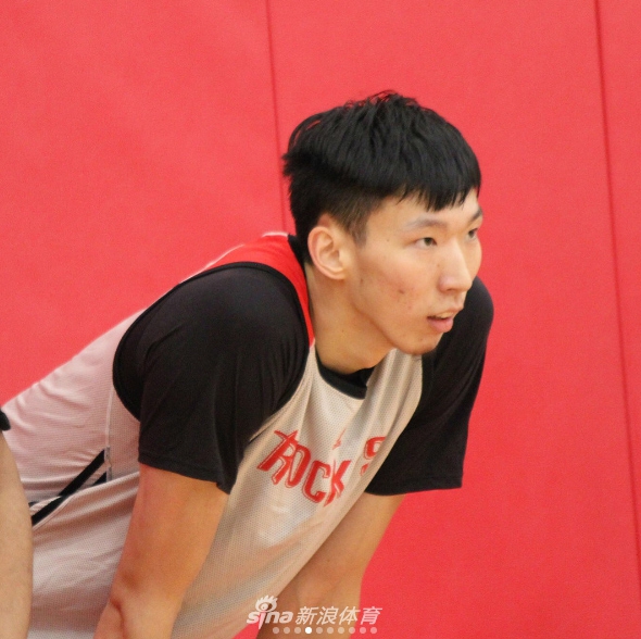 在火箭队的训练馆里，周琦神情专注地跃起投篮，目光紧盯着篮筐，肌肉线条在灯光下显得结实有力，每一个细节都透露着他在休赛期苦练的成果。