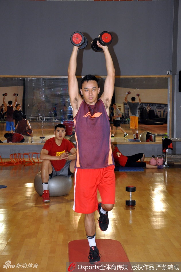 王汝恒紧咬牙关，奋力向上推举杠铃，手臂肌肉线条在灯光下显得格外分明