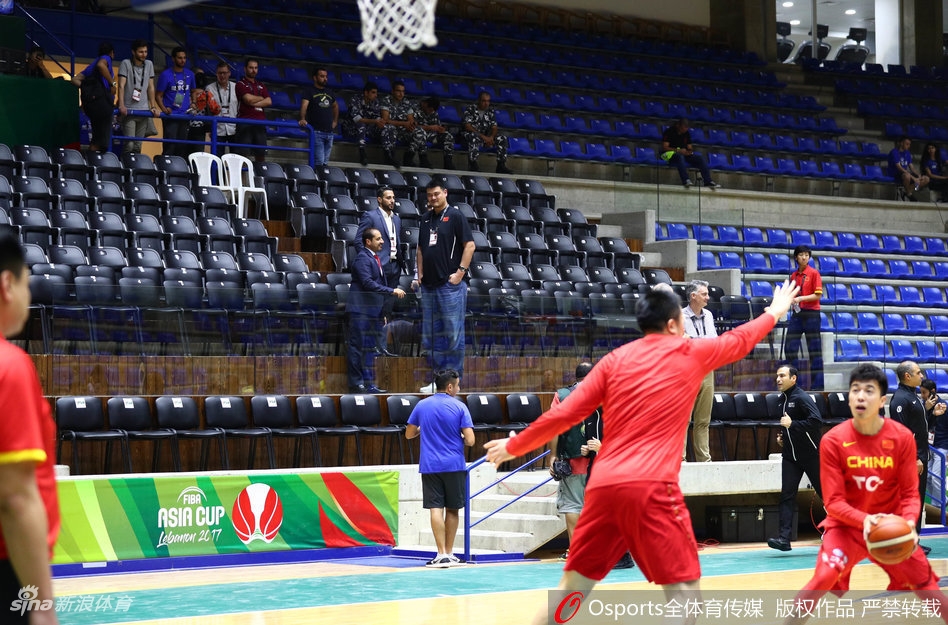 姚明端坐于看台之上，眼神中透露出对赛况的关切与深思，仿佛在脑海中快速拆解着场上每一个战术细节。