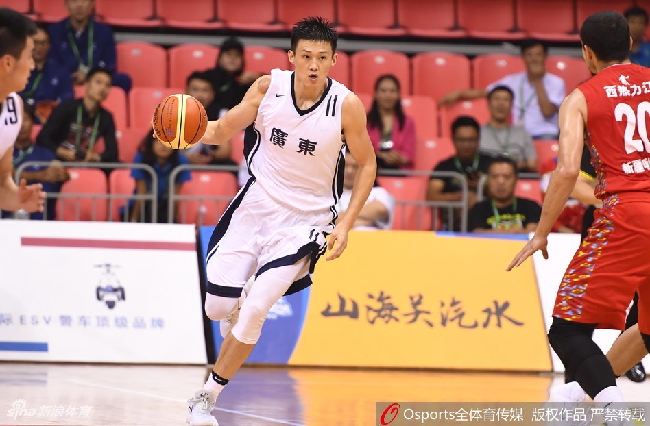 广东队长周鹏在防守端滑倒后坐在地上，无奈地摊开双手，身后的新疆球员正庆祝得分