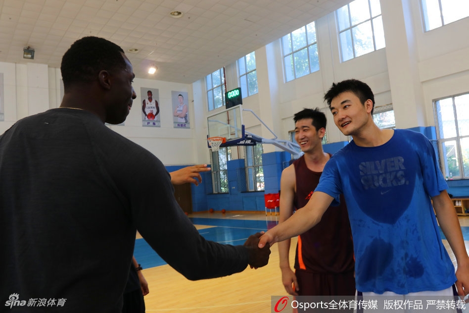 巴斯在训练馆内饶有兴致地观看着墙上教练和队友的照片,墙上按照球衣号码排列的巨幅照片吸引了他的目光。