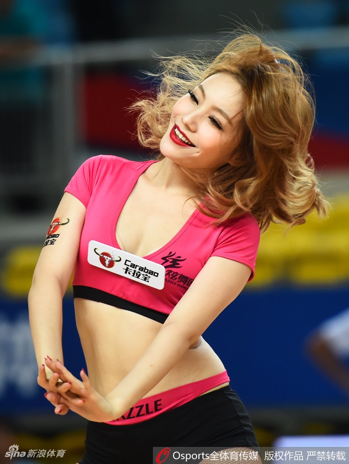 炫舞团啦啦宝贝们身穿统一的粉红色服装，在球场中央腾空跃起，笑容如阳光般灿烂，瞬间点燃全场热情