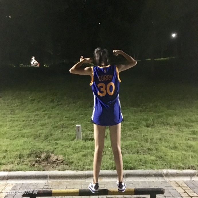 阳光洒在球馆木地板上,鲁西西ii身穿库里30号球衣回眸一笑,修长身影与篮筐构成一幅活力画卷