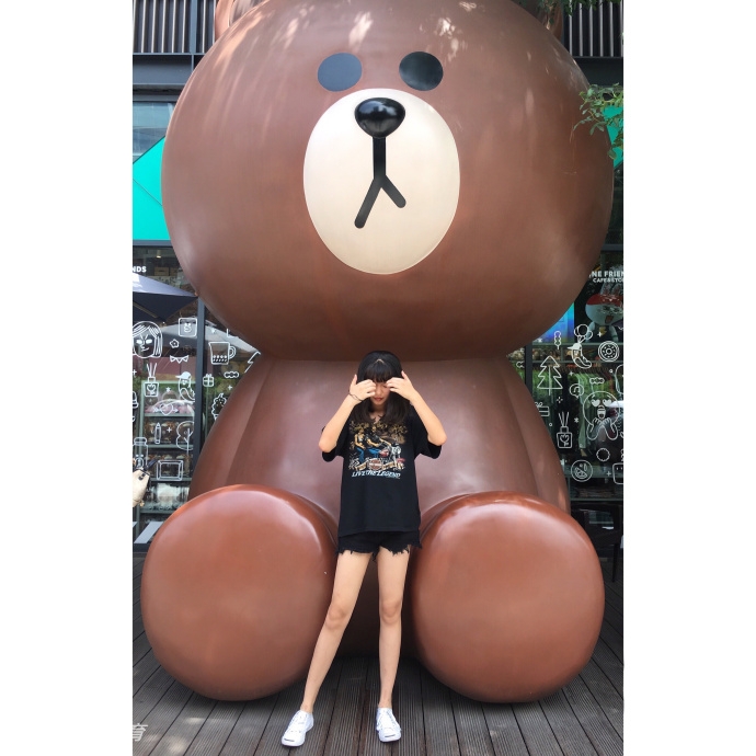 鲁西西ii在球场中线附近席地而坐,双腿自然伸展,背景的篮球架与她的笑容相映成趣,画面充满了故事感