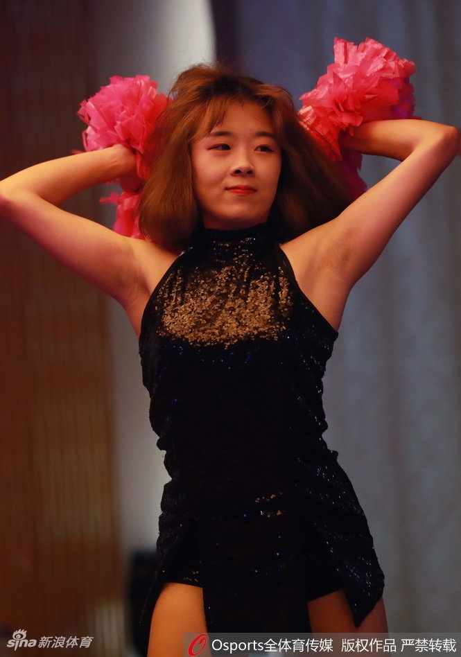 镜头特写下，啦啦队员扎着利落马尾，汗水闪烁在青春的脸庞上，专注的眼神和灿烂的笑容展现了篮球宝贝的独特魅力。