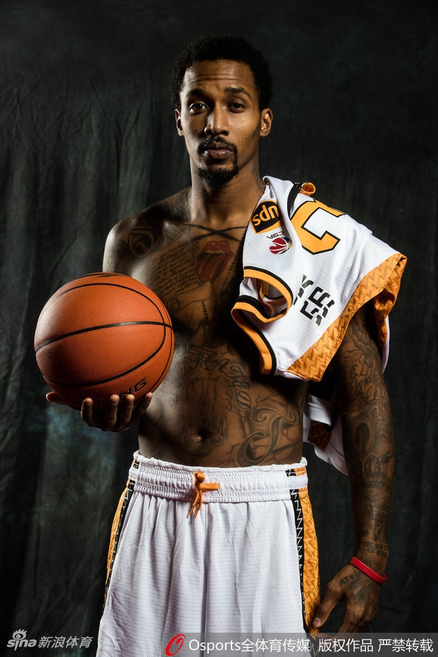 山西男篮教练组与队员们一起拍摄大合影，大家紧密地靠在一起，对着镜头露出灿烂的笑容，教练也比出大拇指，背景是球队新赛季的官方背景板，气氛融洽。