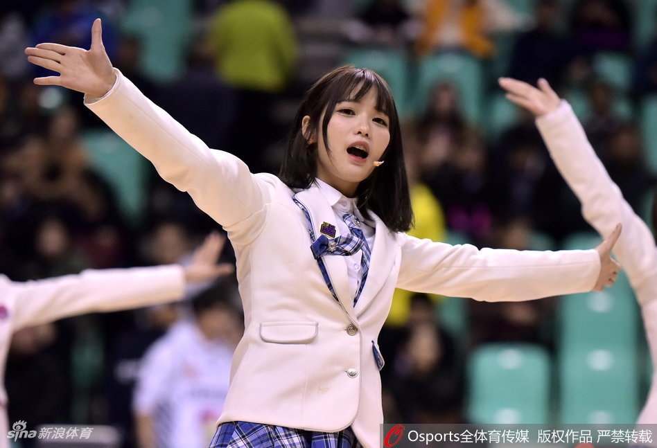 SHY48成员以体育馆大屏幕为背景摆出可爱的加油手势,身后是热烈的比赛现场,她们的笑容与场馆内的灯光交相辉映。