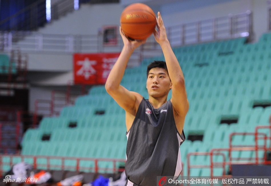 郭艾伦热身时与队友互动,他歪着头听队友说话,脸上露出略带狡黠的浅笑,画面充满兄弟情谊。