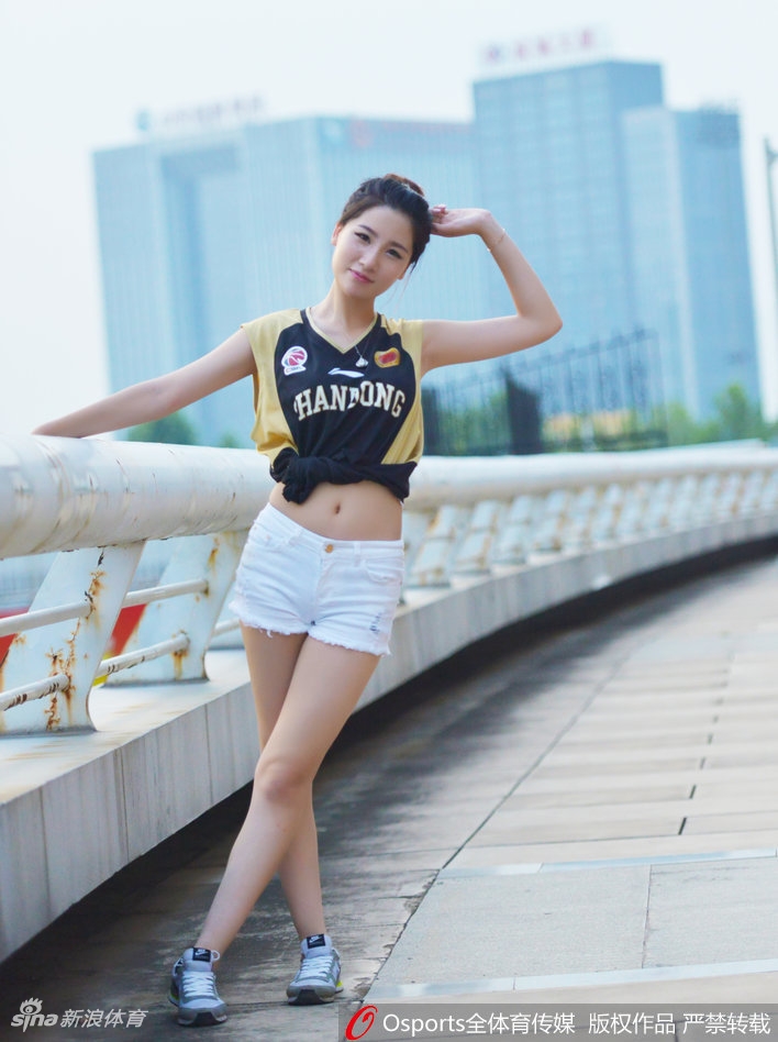 场边最美的风景线，一位山东女球迷身着紧身橙色球衣，搭配白色热裤，她高扎马尾，眼神专注地望向赛场，双手竖起大拇指，用灿烂的笑容为心中的英雄们送上最真挚的赞赏与鼓励。