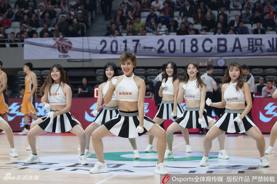 表演中，一名队员做出了一个高难度的空中劈叉动作，身体线条优美而充满力量。她手中的花球仿佛被赋予了生命，在空中划出绚丽的轨迹，定格成赛场上最富动感的瞬间。