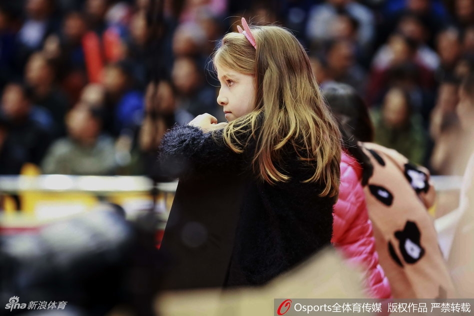 莫泰尤纳斯的小儿子戴着毛线帽，在母亲怀里好奇地东张西望，球馆的喧嚣对他来说更像是新奇的交响乐。