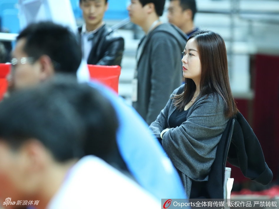 一位笑容灿烂的女球迷在人群中格外醒目,她身着休闲冬装,双手轻抚脸颊,青春的气息扑面而来