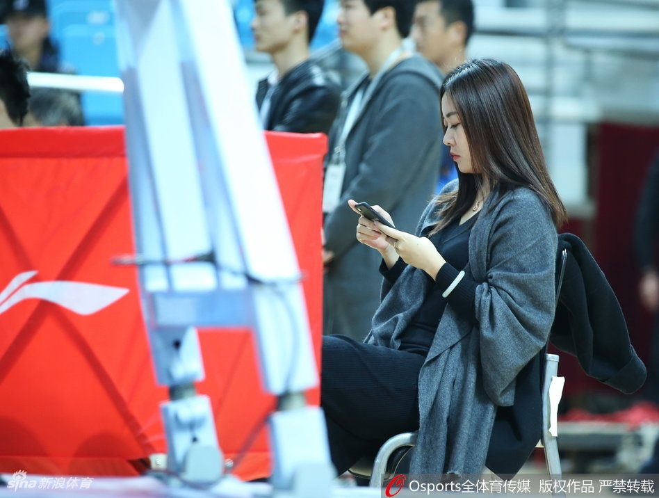 一位穿着时尚的短发女球迷侧身而立,在赛场背景的映衬下,轮廓分明,显得既酷又充满活力