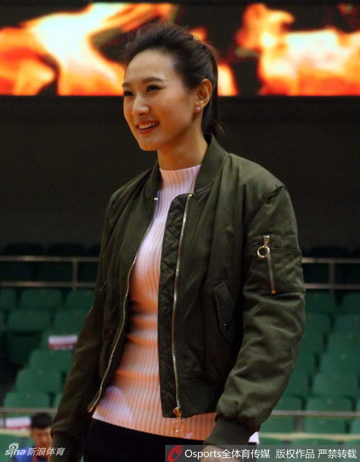一笑一颦间透露出职业的自信,她站在篮架后方的摄影席上,宛如喧嚣场馆中一抹沉静而亮眼的色彩。