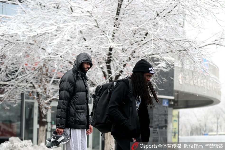 广厦球员胡金秋在乌鲁木齐大雪中露出灿烂笑容,身后的街景已被白雪覆盖,南方少见的大雪让他显得格外兴奋。