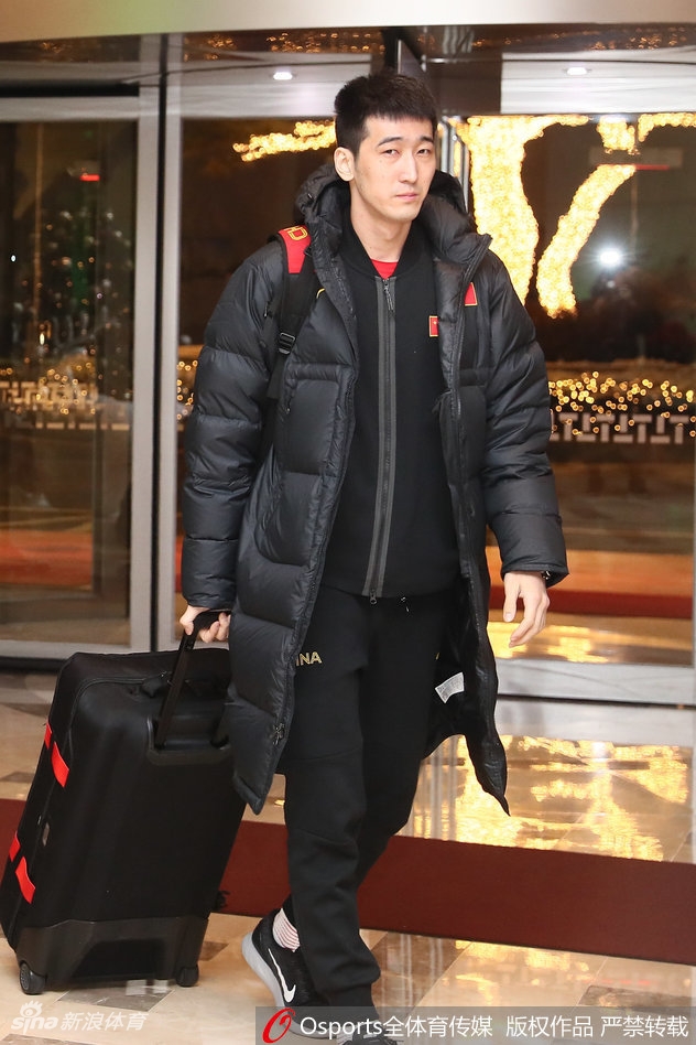 身着红色运动外套的中国男篮队员们一字排开，在领队的带领下有序步入酒店大堂，走在最前方的球员眼神坚毅，仿佛已将客场喧闹隔绝在外。