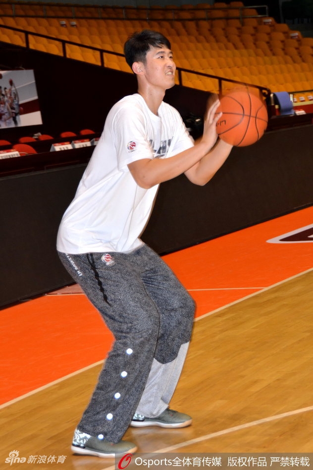 助教鞠维松正全神贯注地指点着张春军的投篮手型,篮筐之下,是打磨技术的宁静角落。