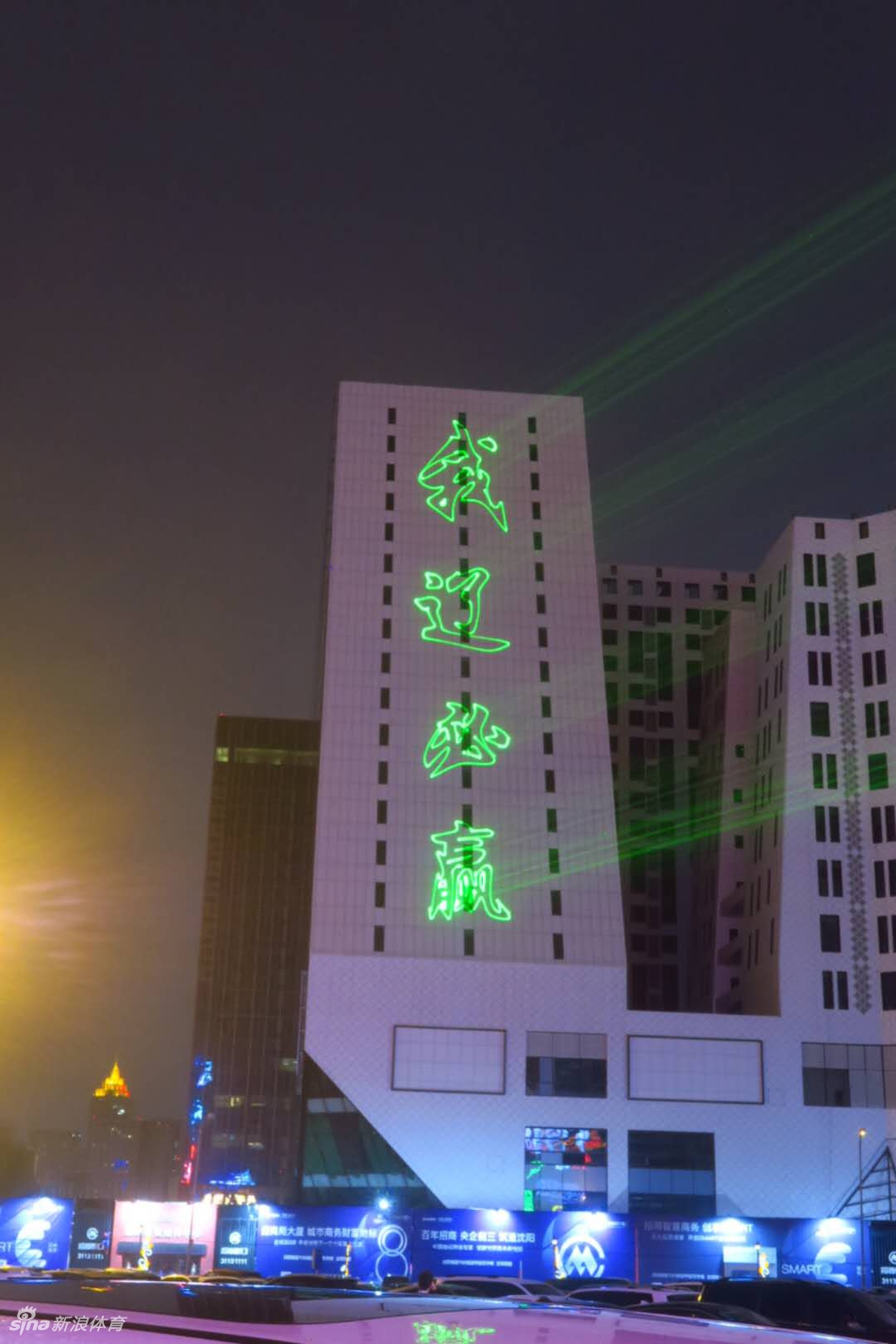 楼体上巨大的“1234 我爱辽篮”投影，简洁有力的口号在夜空中闪烁，道出了所有球迷共同的心声。