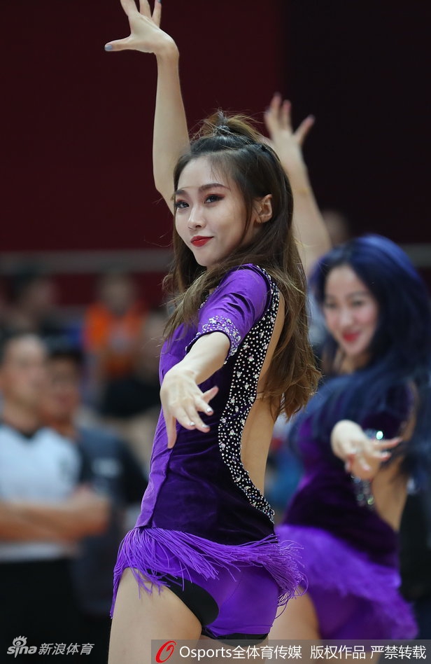 一名啦啦队员回眸瞬间，发丝飞扬间尽显青春活力与赛场激情