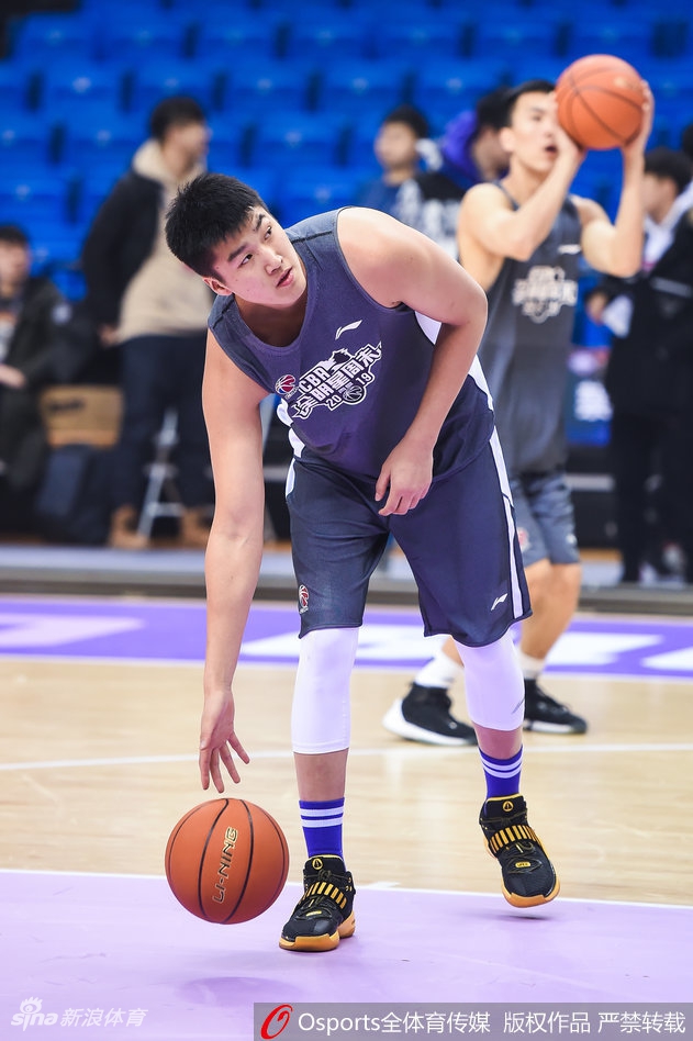 训练结束后，一名球员独自坐在场边的座椅上，低头解着鞋带。周围是散落的篮球和矿泉水瓶，巨大的球馆衬托出他略显孤独的身影，仿佛是一个刚刚结束加练的侠客，享受着喧嚣后的片刻宁静。