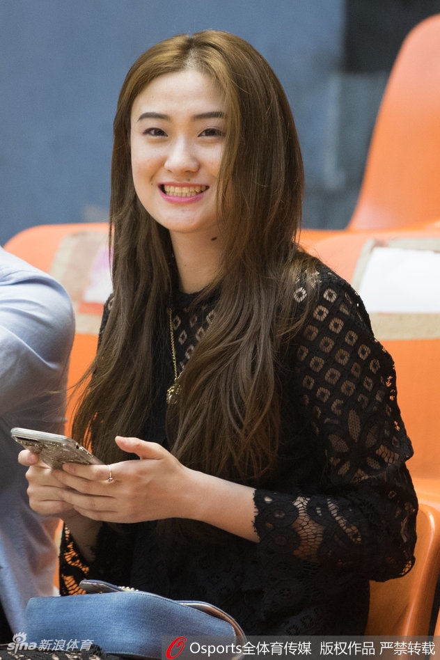 赛场边的广厦美女球迷专注地盯着球场方向，紧握的双手透露出内心的紧张，她正在为场上的每一次攻防转换而心跳加速。