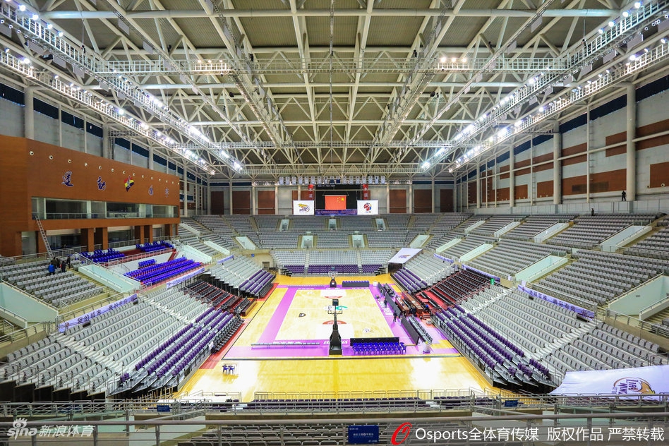 辽宁体育馆内场全景，洁白的座椅与鲜红的横幅交相辉映，气势恢宏。